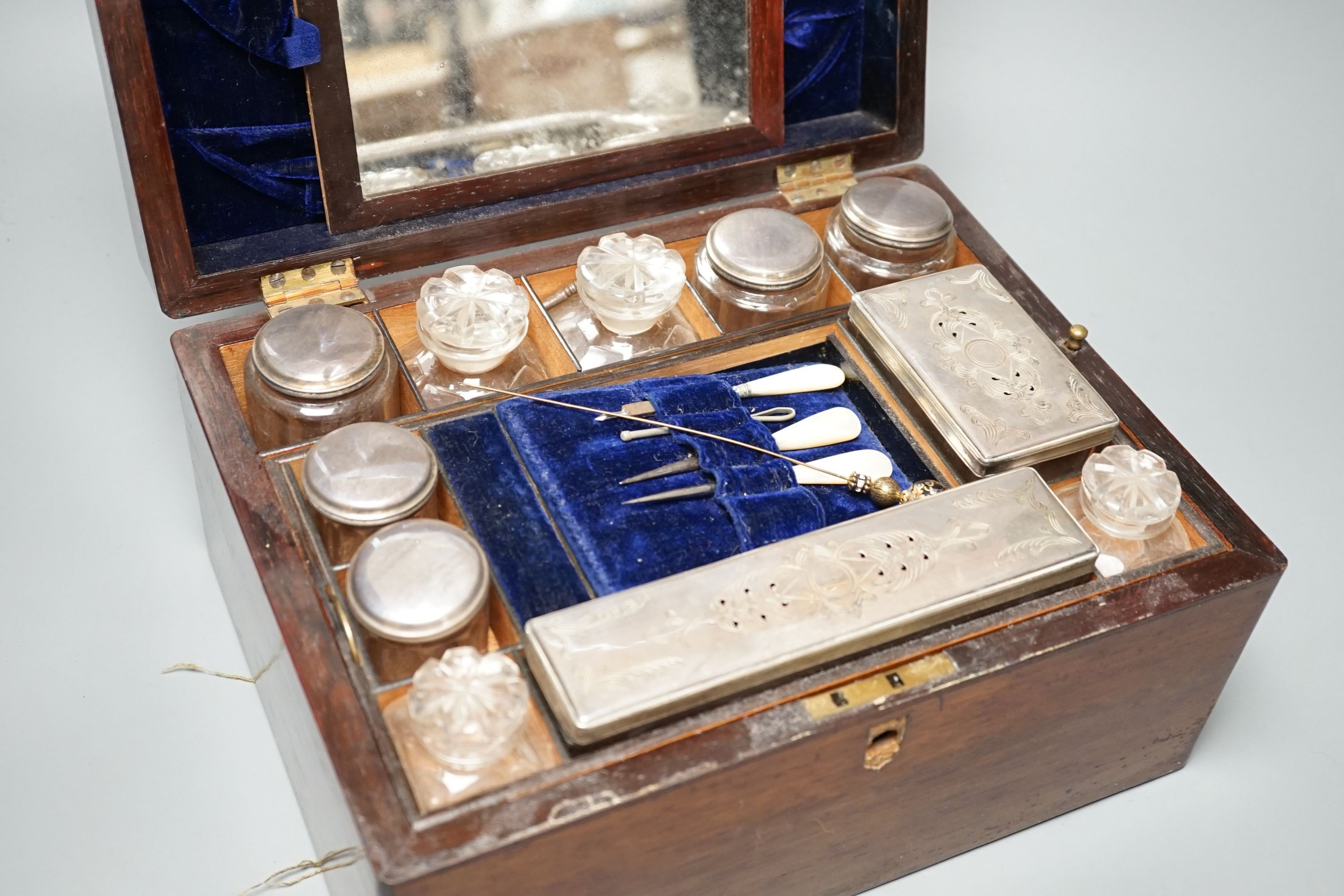Two Victorian rosewood cased travelling vanity sets with silver plated covers (2)